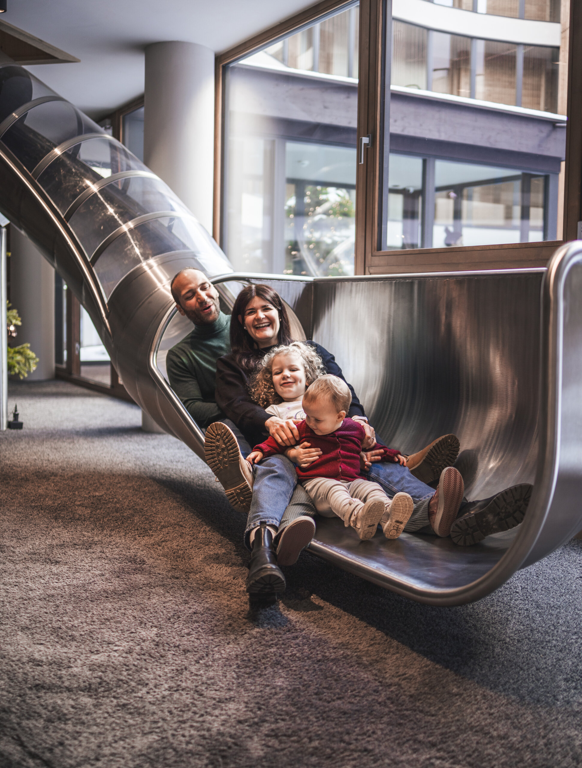 Eltern mit zwei Kindern auf der Rutsche - Hotel Familiamus