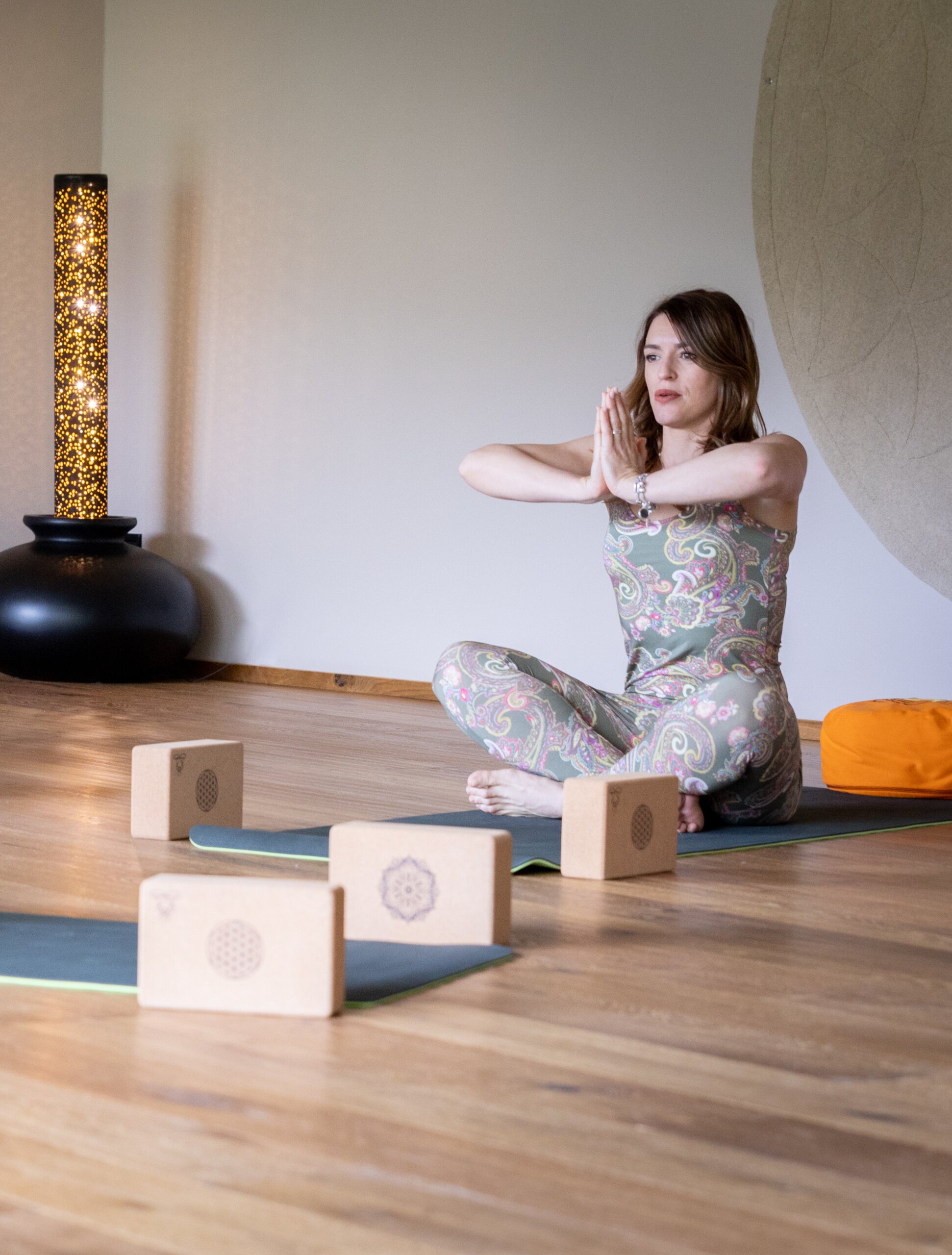 Frau beim Meditieren auf der Yogamatte - Hotel Familiamus