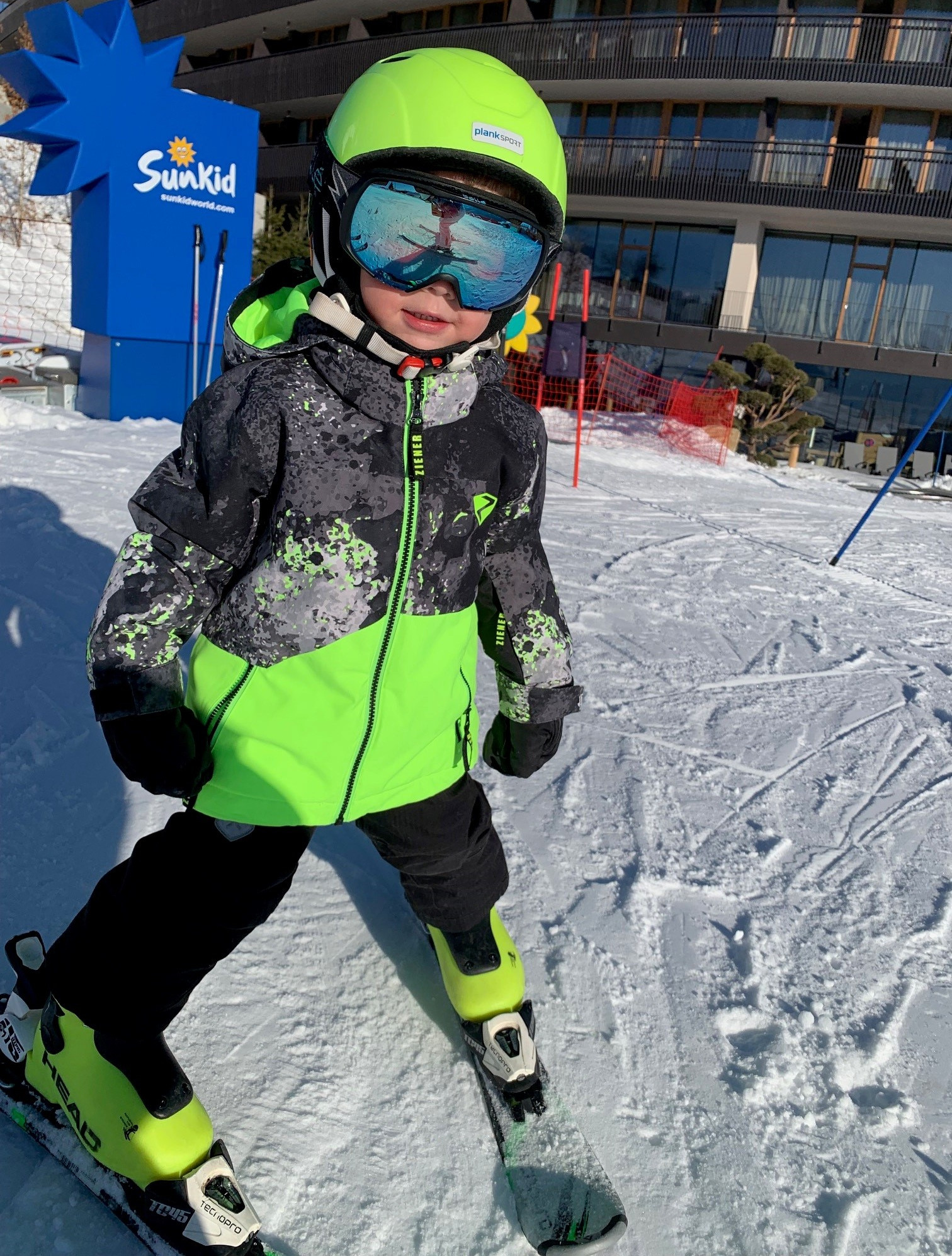 Child with skis in front of the Hotel Familiamus