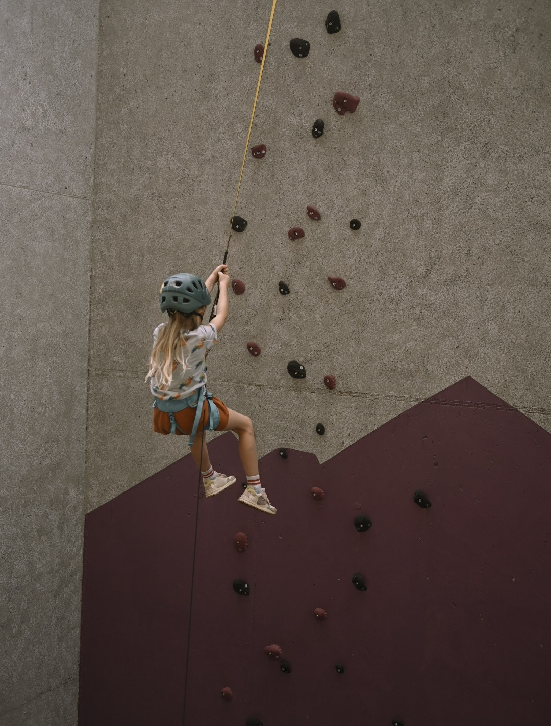 Mädchen im Klettergurt an der Kletterwand - Hotel Familiamus